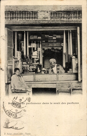 Ak Tunis Tunesien, Eine schwarz-weiße Fotografie zeigt einen Mann mit Fez, der in einem Geschä...
