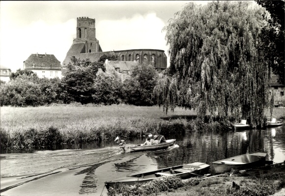 Ak Beeskow in der Mark, Riverszene mit Boot, Kirche im Hintergrund, baumumsäumter Fluss