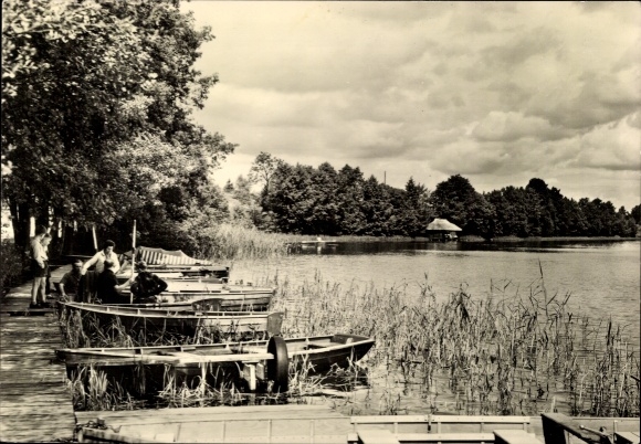 Postcard Kagar Rheinsberg in Brandenburg, boats on the shore, green trees, clouds in the sky, lake in the background