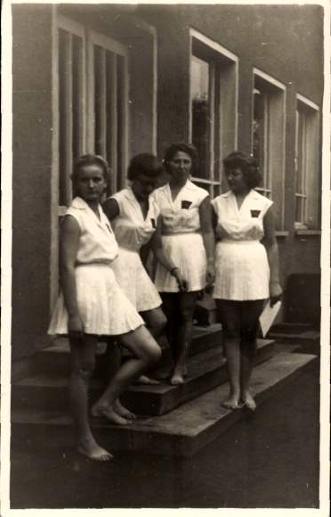 Foto Vier junge Frauen auf der Treppe vor einem Haus, weiße Kleider, barfuß