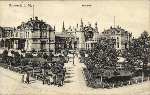 Ak Schwerin in Mecklenburg, Bahnhof,  Gebäude, Gartenanlage, Menschen auf der Straße