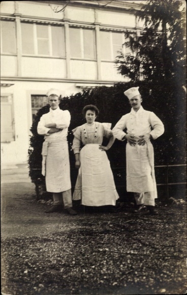 Foto Ak Köche und Köchin vor einem Gebäude, Portrait