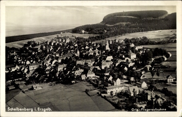 Ak Scheibenberg im Erzgebirge, Luftaufnahme von Scheibenberg, viele Häuser, Kirche, bewaldeter Hü