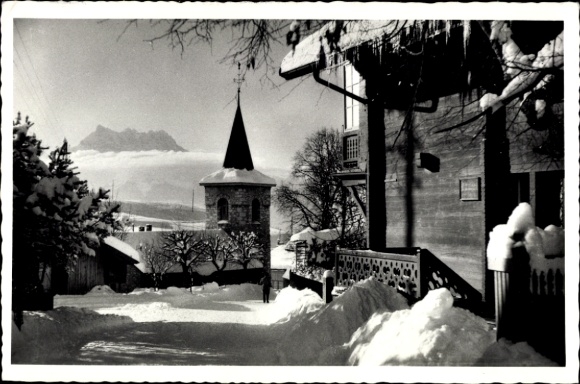 KP Leysin, kanton Vaud, krajobraz pokryty śniegiem, kościół z wieżą w kształcie spiczastego łuku, góry w tle