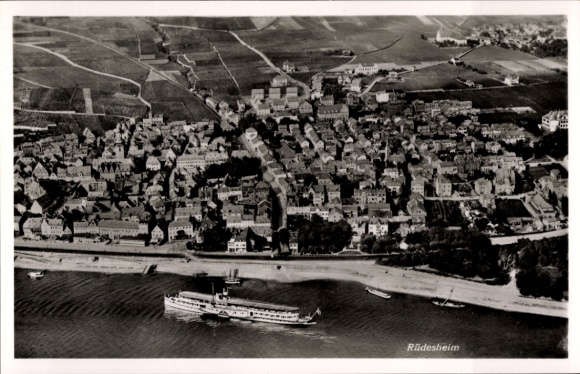 Postcard Rüdesheim am Rhein, aerial view of ships in the water, vineyards in the background