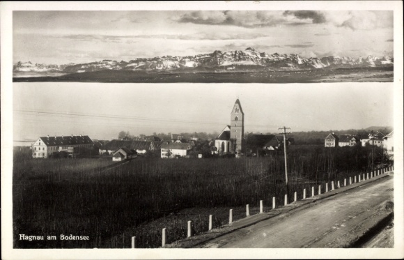 Ak Hagnau am Bodensee, Landschaft mit Kirche, umliegende Gebäude, Bergpanorama