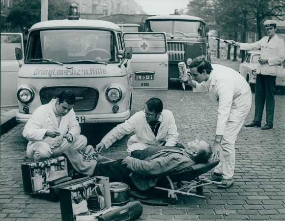 Photo Berlin, wounded man on a stretcher, medic, traffic policeman, Barkas, Ifa truck, GDR