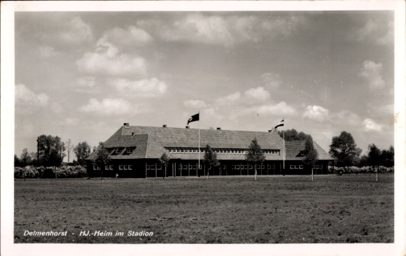Postcard Delmenhorst in Oldenburg, HJ home in the stadium, building with flags, clouds in the sky