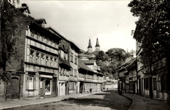 Ak Nordhausen am Harz, Straße mit Fachwerkhäusern, zwei Türme im Hintergrund
