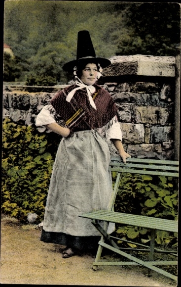 Postcard Swansea Wales, A young woman in traditional Welsh costume stands in front of a stone masonry...