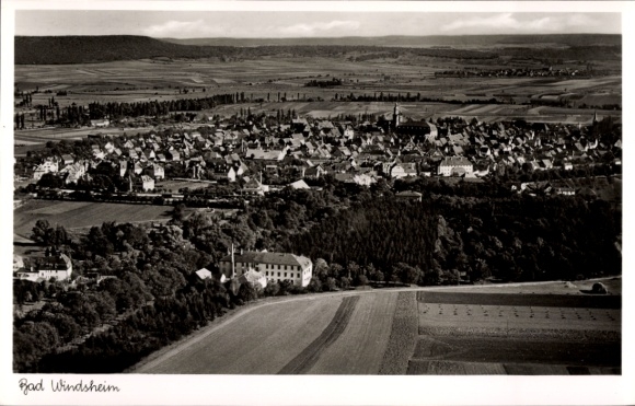 Ak Bad Windsheim in Mittelfranken, Luftansicht von  viele Häuser, grüne Felder, Berge im Hintergr