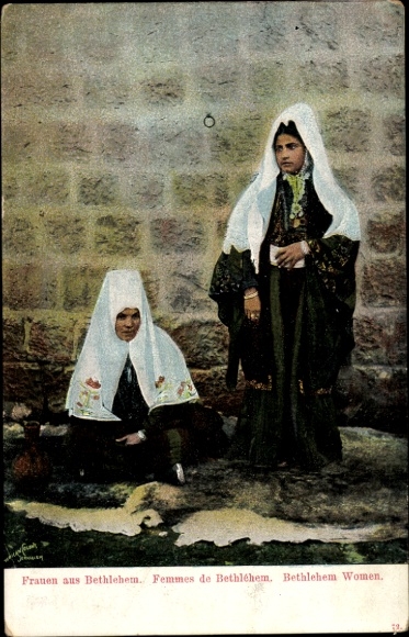 Ak Bethlehem Palästina, Zwei Frauen in traditioneller Kleidung vor einer Mauer.