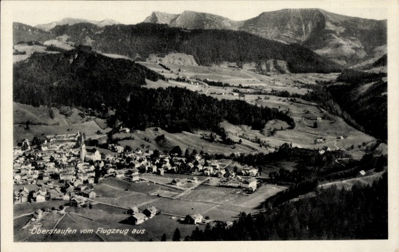 Ak Oberstaufen im Allgäu, Luftbild von  Berge im Hintergrund, Üppige grüne Wiesen