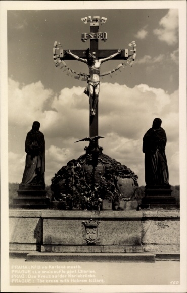Ak Praha Prag Tschechien, Kreuz auf der Karlsbrücke, Statue, Inschrift in mehreren Sprachen