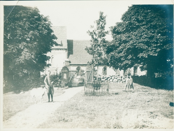 Photo Ostseebad Koserow on Usedom, boy with goat in front of a church