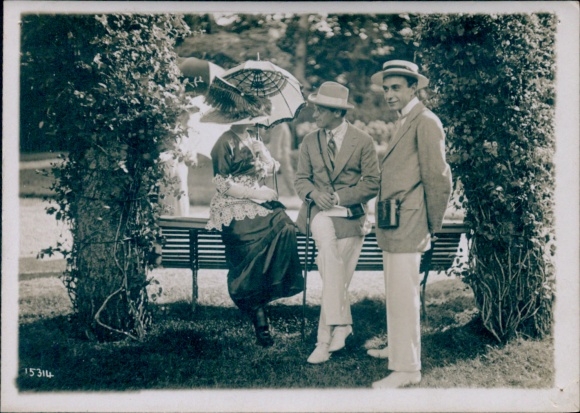 Photo fashion in France, woman with parasol, men in suits