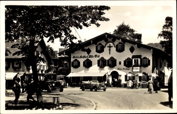 Postcard Oberammergau in Upper Bavaria, house with cross, old cars, people, cloudy sky