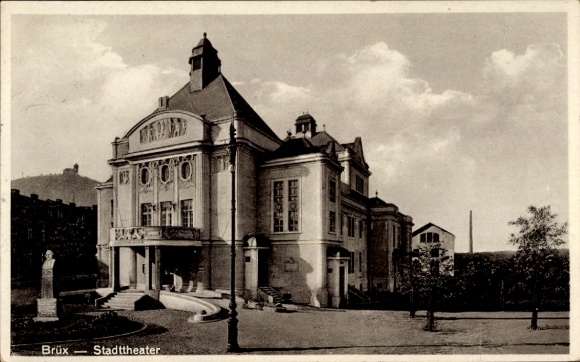 Ak Most Brüx Region Aussig, Stadtthater,  Architektur, Monument, Bäume vor Theater