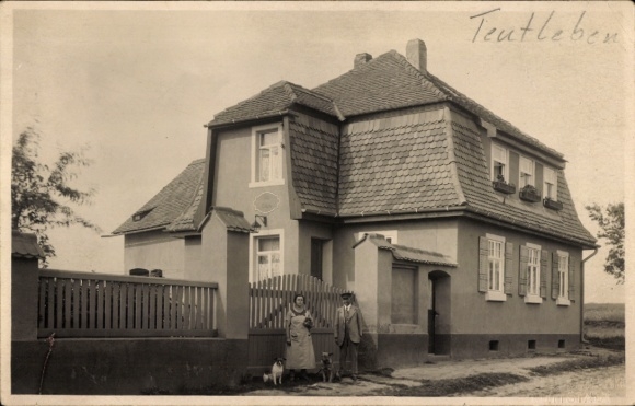 Ak Teutleben Hörsel Thüringen, Haus mit Sandsteinsockel, zwei Personen, Holzpferd, Schrift 'Teutl