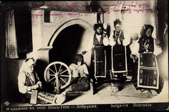 Postcard Women in Bulgarian folk costumes, living room, spinning wheel