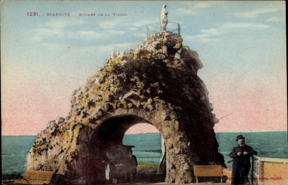 Ak Biarritz Pyrénées Atlantiques, rots met standbeeld, zee op de achtergrond, twee mensen, bankjes