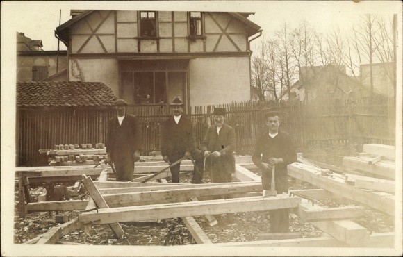Photo Postcard Men on a construction site, wooden beams, scaffolding