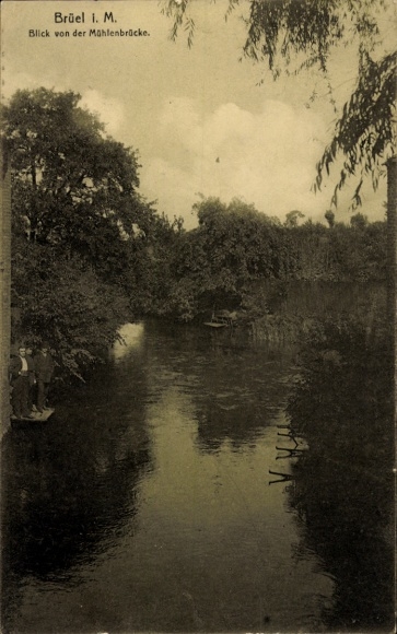 Postcard Brüel in Mecklenburg, Brüel i. M., view from the mill bridge, calm river, green trees