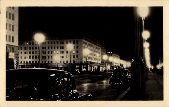 Ak Berlin Friedrichshain, Stalinallee bei Nacht, Beleuchtung, Autos
