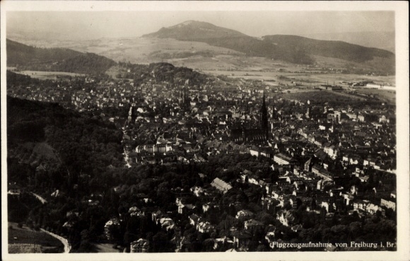 Ak Freiburg im Breisgau, Luftaufnahme von Freiburg, Berge im Hintergrund, Stadtansicht, Schwarz-W