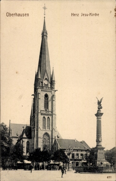 Ak Oberhausen im Ruhrgebiet, Herz Jesu-Kirche, hoher Kirchturm, Monument davor, Bäume,  