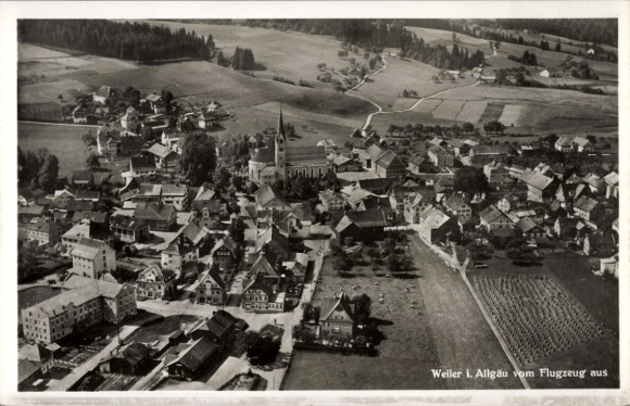 Ak Weiler Simmerberg im Allgäu, Luftaufnahme des Weilers, Kirche sichtbar, ländliche Umgebung, kl