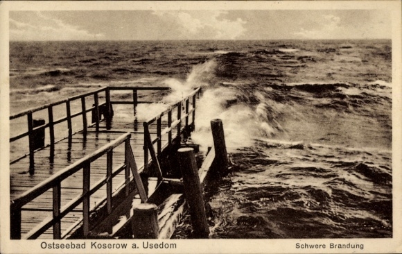 Ak Ostseebad Koserow auf Usedom, Ostseebad Koserow, bewegte Brandung, Holzsteg, dunkle Wolken