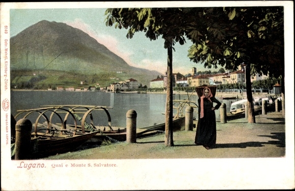 KP Lugano Kt. Ticino Szwajcaria, Quai e Monte S. Salvatore, brzeg rzeki, kobieta z sakwami