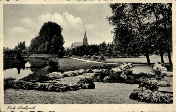Postcard Goch on the Lower Rhine, city park, church in the background, green meadows, trees, flowerbeds