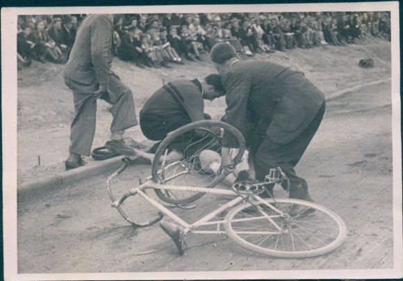 Photo cyclist is taken care of after a fall, racing bike