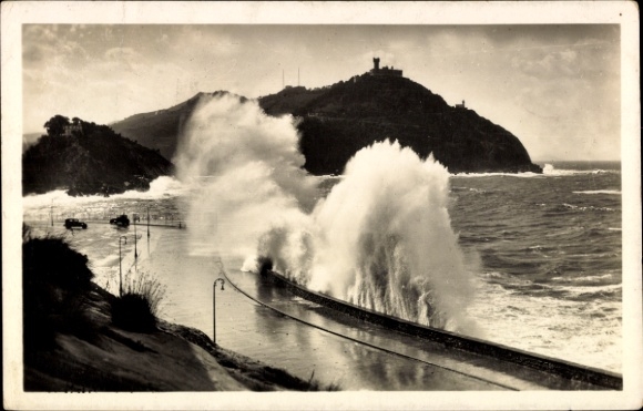 KP Donostia San Sebastian Kraj Basków, fale rozbijające się o wybrzeże, w tle góra, Schwa