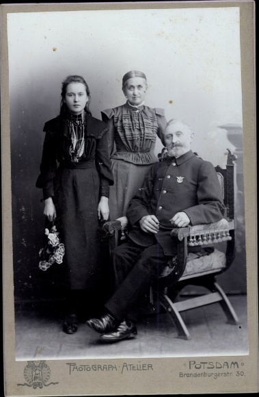 Cabinet photo of railway workers in uniform, portrait with wife and daughter
