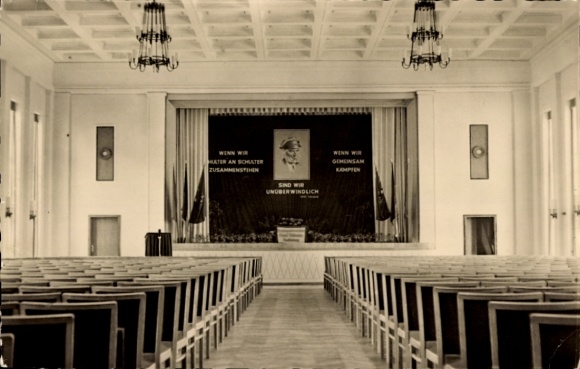 KP Senftenberg w Dolnych Łużycach, pusta sala, scena z transparentem, rzędy krzeseł, klasyczny inte