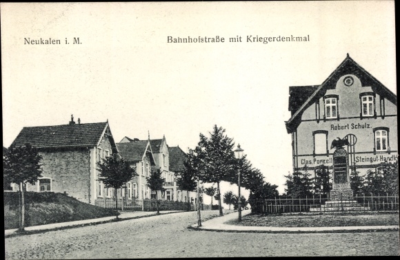 Postcard Neukalen in Mecklenburg, Bahnhofstrasse with war memorial, Robert Schulz store