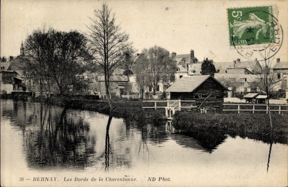 Ak Bernay Eure, Flussansicht, hölzernes Haus, Häuserzeile, Bäume