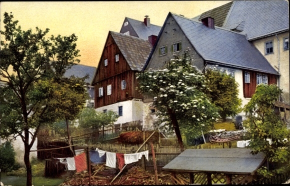 Ak Altenberg im Erzgebirge, Farbige Holzhäuser, grüne Bäume, Wäscheständer mit Kleidung, Umgebung