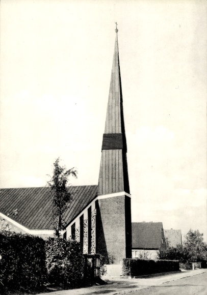 Ak Ahrensburg in Holstein, St. Johannis-Kirche, spitziger Kirchturm, umliegende Wohnhäuser