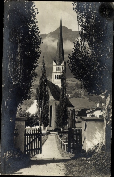 Ak Bad Hofgastein in Salzburg, Kirche mit spitzem Turm, Weg mit Zaun, Bäume, Berg im Hintergrund