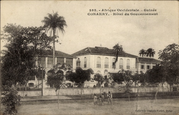 Ak Conakry Guinea, Hôtel du Gouvernement, met palmen omzoomd gebouw, historische ansichtkaart, Afrika