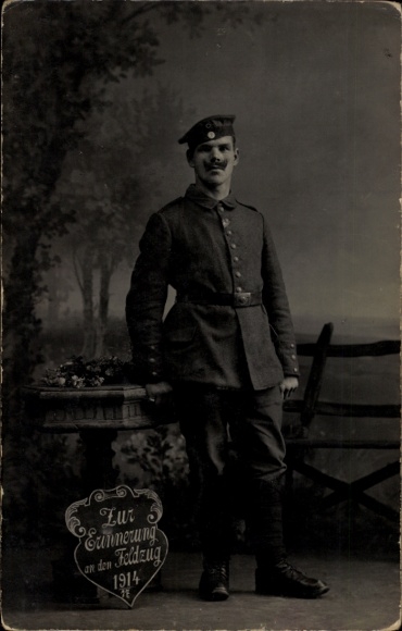 Ak Saarburg an der Saar Bezirk Trier, Ein Soldat in Uniform steht vor einem Baum. Er hat einen...