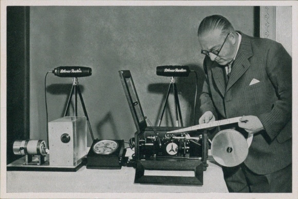 Obraz kolekcjonerski przedstawiający Igrzyska Olimpijskie 1936, aparat do nagrywania filmów, zegarek precyzyjny, chronograf rejestracyjny, fotografia tarczowa