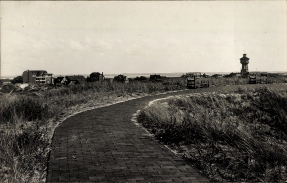 Postcard North Sea resort Spiekeroog in East Frisia, path on the dike, water tower