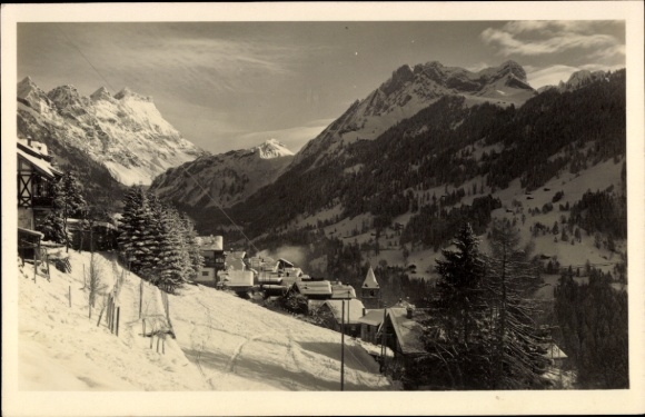 KP Les Diablerets Canton Vaud, ośnieżone góry, małe domy, drzewa iglaste, czysty widok