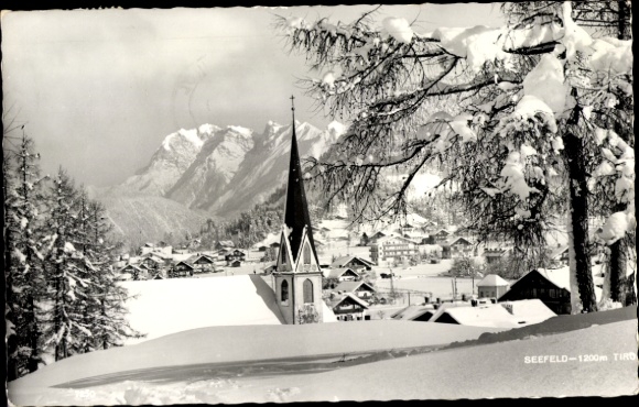 Ak Seefeld in Tirol, Schneebedeckte Landschaft, Kirche mit spitzem Turm, Berge im Hintergrund