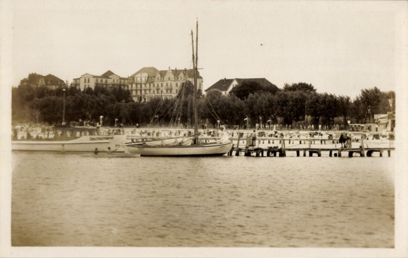 Ak Ostseebad Grömitz in Holstein, Hafen mit Segelbooten, Gebäude im Hintergrund, Pier mit Mens...